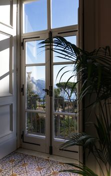 Elegant French doors open to a lush garden with a scenic mountain view.