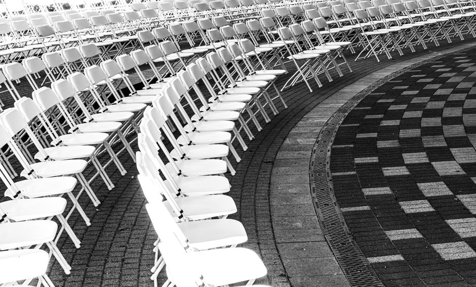 White chairs arranged in curved rows for an outdoor ceremony in Northern Michigan