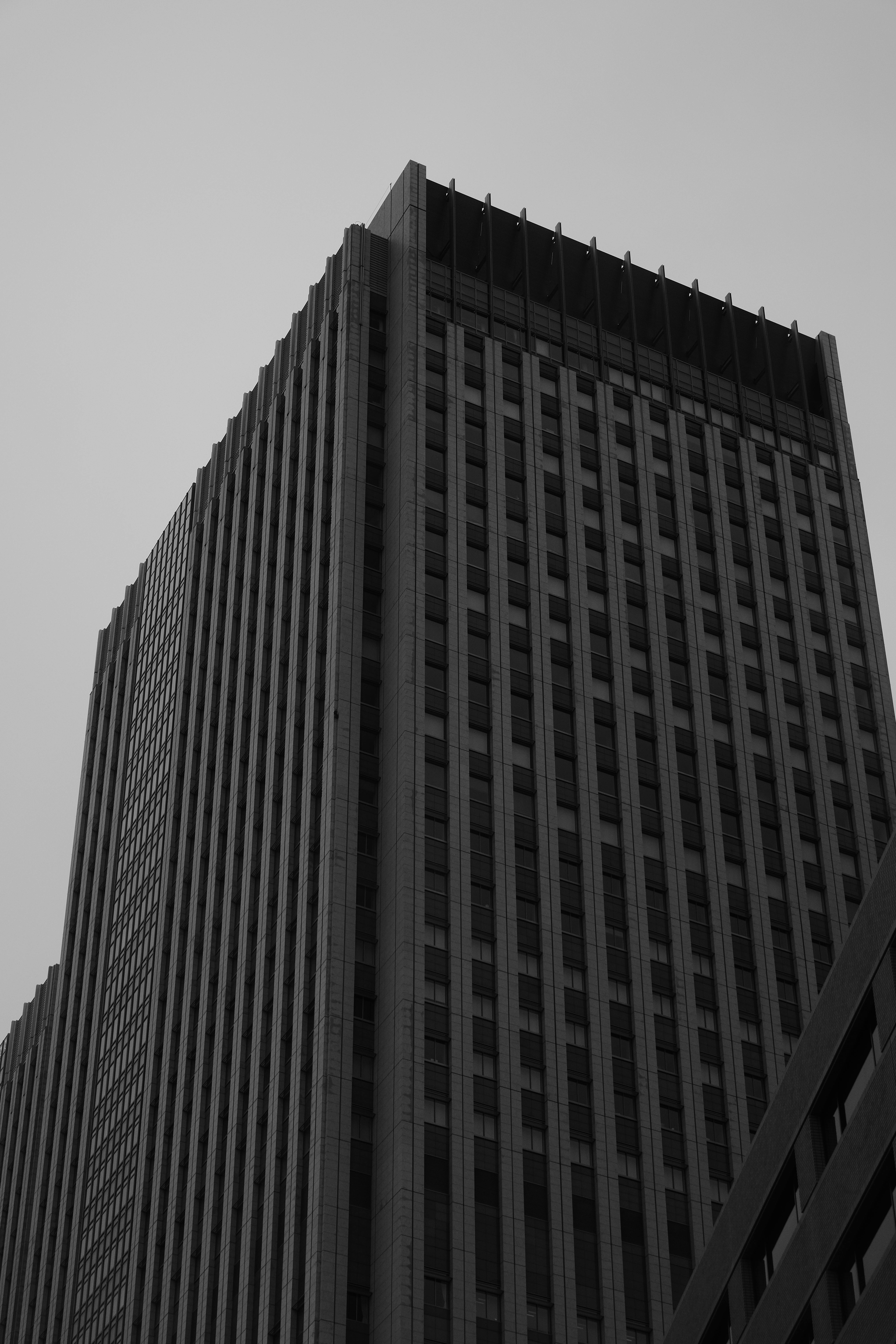 grátis Fotografia em preto e branco de um arranha-céu em Tóquio, capturando sua arquitetura moderna e imponente. Foto profissional