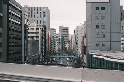 Free Moody urban street view of Tokyo's towering skyscrapers and bustling city streets. Stock Photo