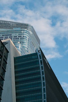Capture of a modern Tokyo skyscraper reaching into the blue sky, showcasing urban architecture.