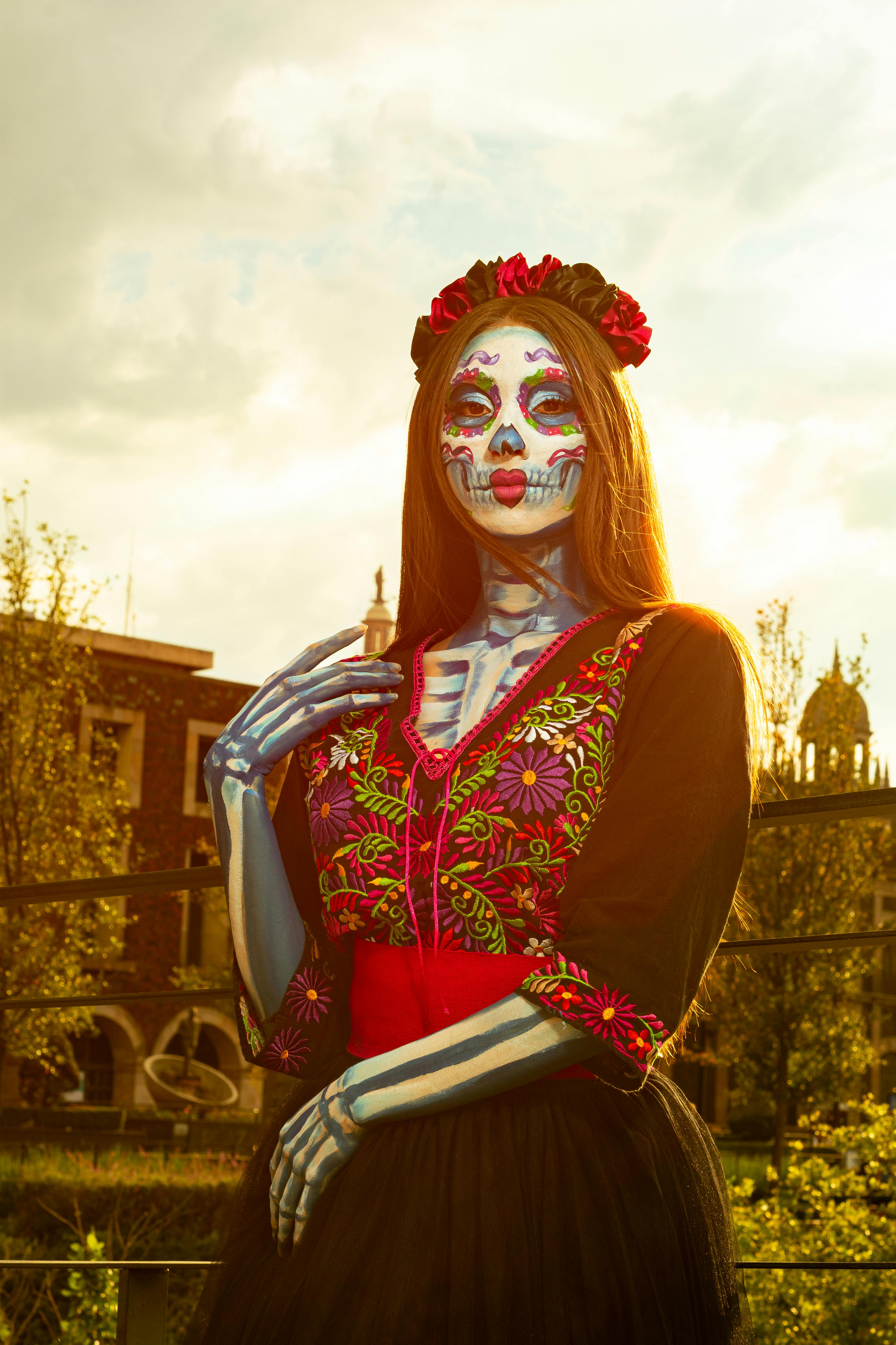 De franc Dona disfressada del Dia dels Morts amb maquillatge tradicional posa a l'aire lliure a la llum del sol. Foto d'estoc