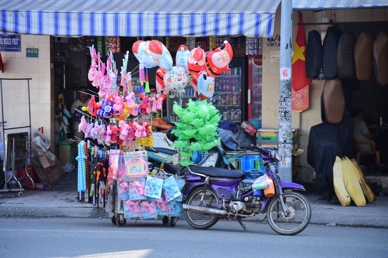 colorful street vendor motorcycle displaying toys and balloons on an u