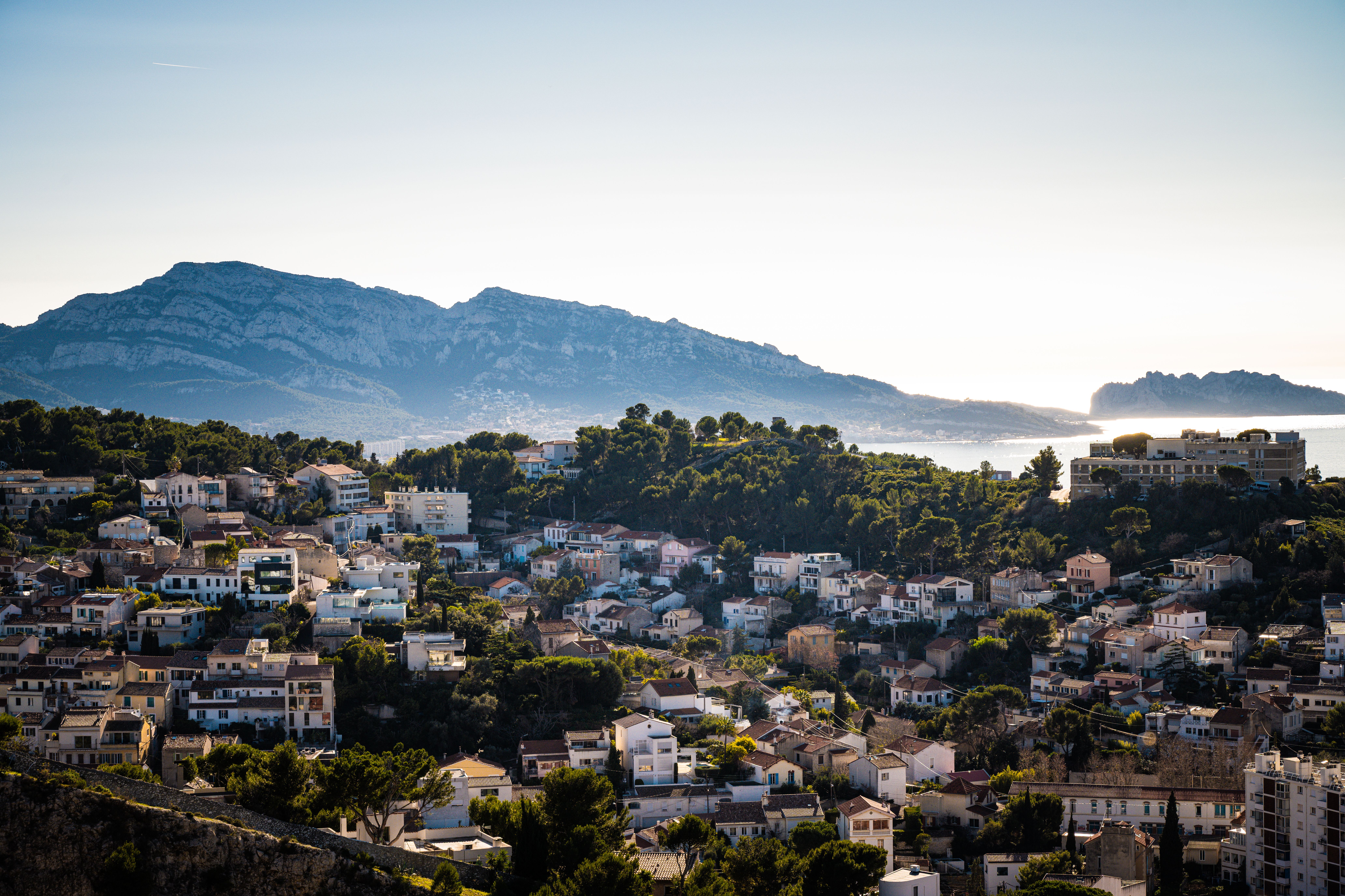 Aerial view of Marseille, France showing urban landscape against a mountain backdrop at daytime. Aerial view of Marseille, France showing urban landscape against a mountain backdrop at daytime.