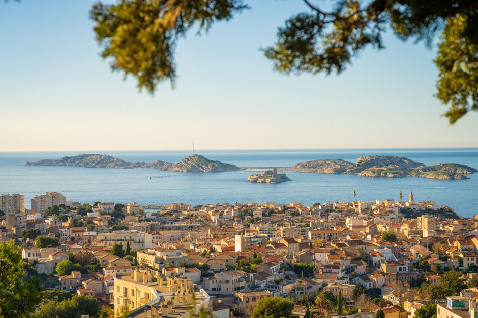 Panoramic view of the city of Marseille with a clear view of the Mediterranean Sea and nearby islands.