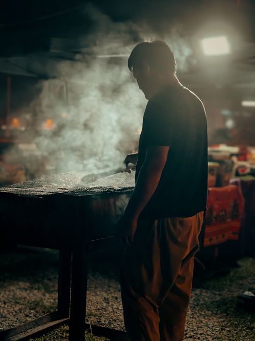 Free A street food vendor grilling at night market in Bintulu, Malaysia, creating a vibrant atmosphere. Stock Photo