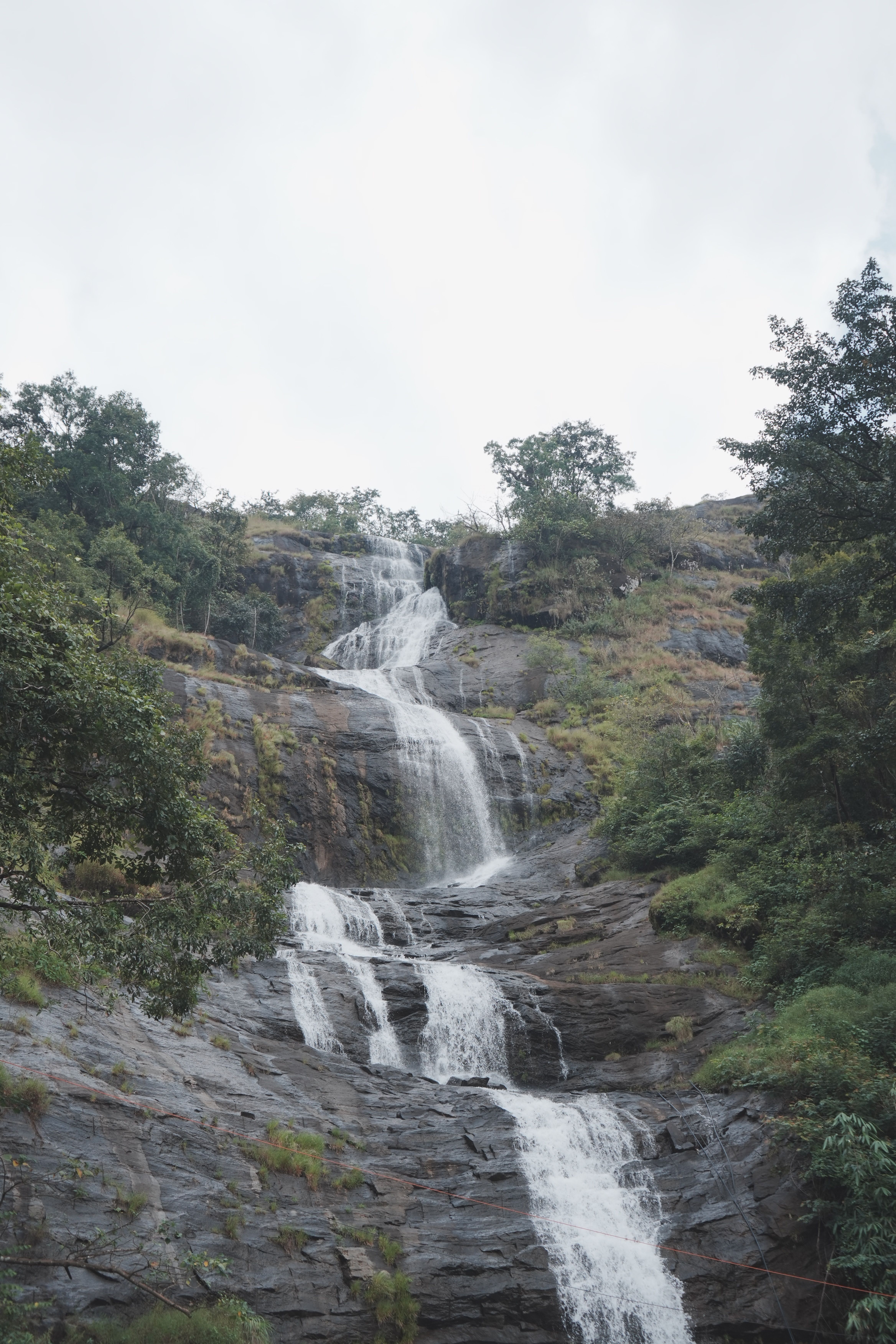 Serene Waterfall Cascading Down Rocky Terrain · Free Stock Photo