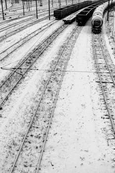 Aerial view of snow-covered railway tracks and trains in Lviv, Ukraine during winter.
