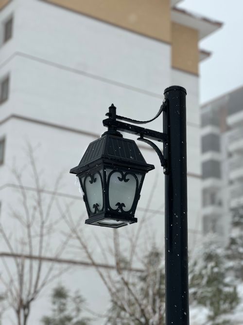 Free Close-up of a vintage street lamp with snowflakes in a winter urban background. Stock Photo