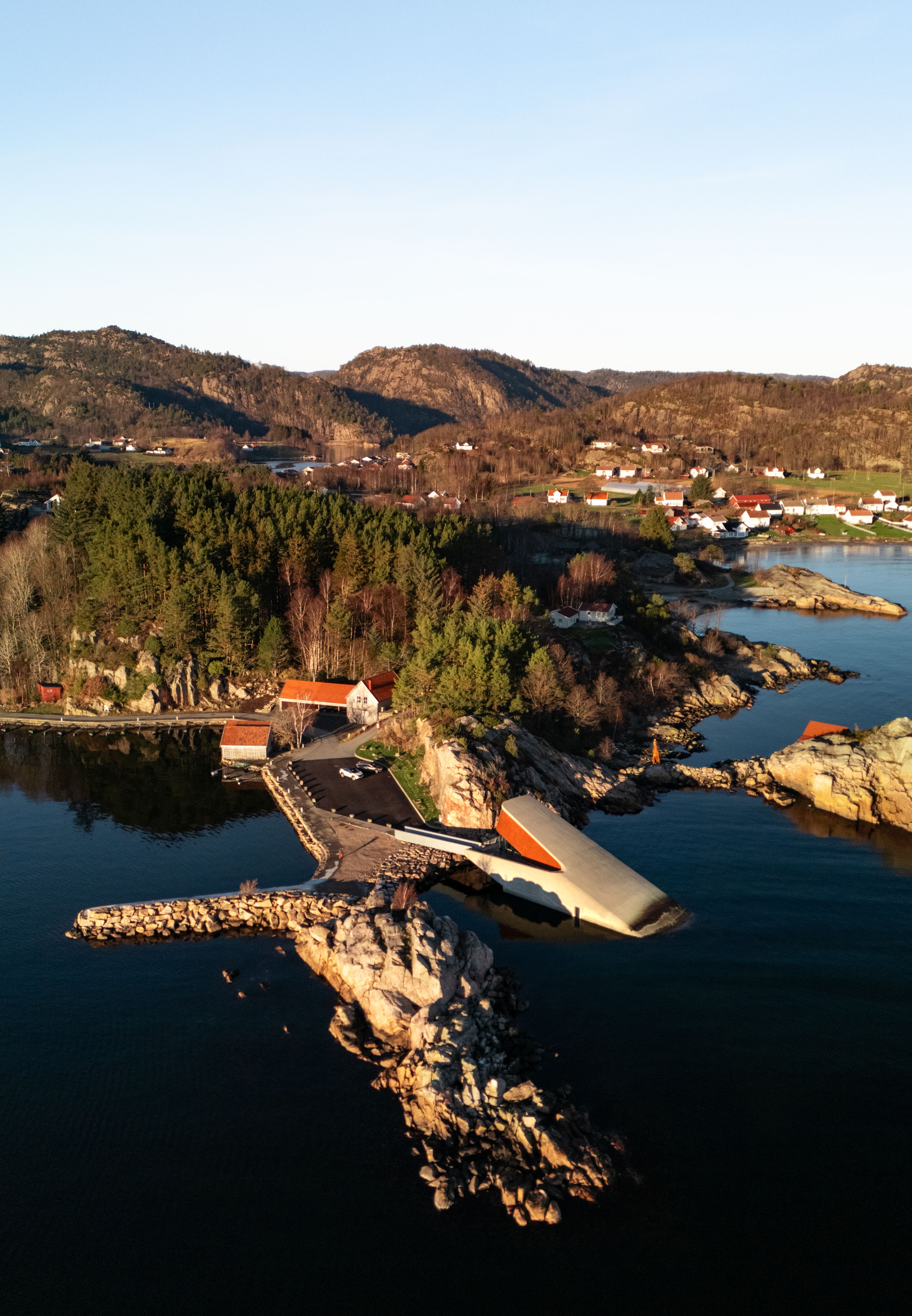 Aerial view of a picturesque Norwegian coastline with unique architecture and serene waters.