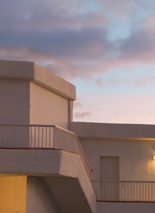 Free Image of a minimalist white building facade against a twilight sky with soft lighting. Stock Photo