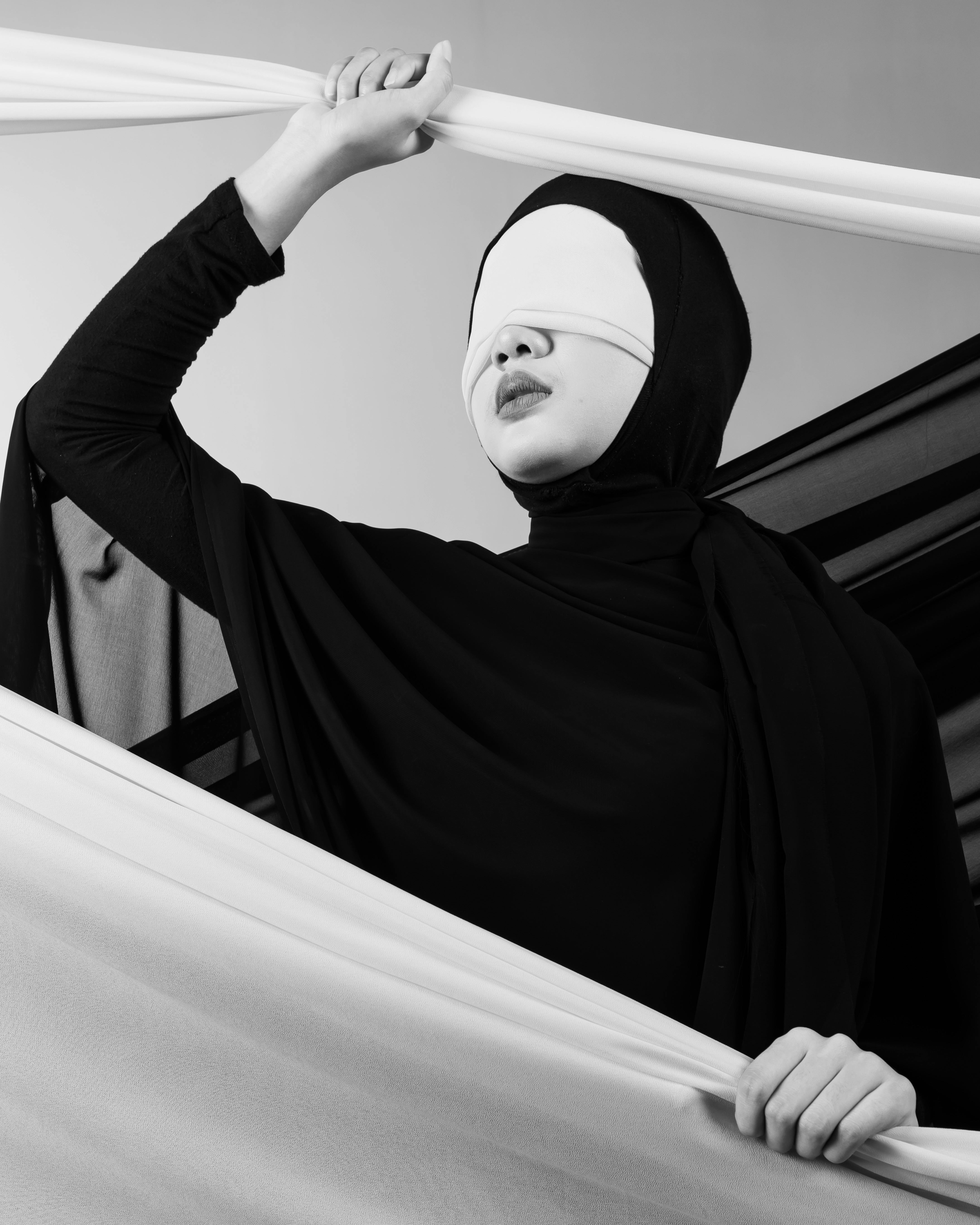 Gratuit Portrait artistique en noir et blanc d'une personne portant un bandeau et un hijab, dans un contexte conceptuel. Photos
