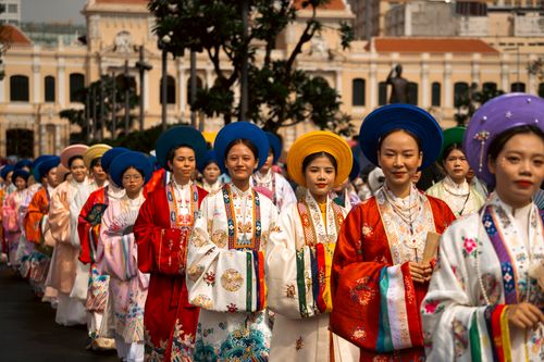 Free Women in colorful traditional Vietnamese attire parade in Ho Chi Minh City, showcasing cultural heritage. Stock Photo