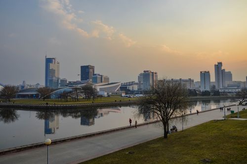 Free A stunning city skyline reflects in a river during sunset, capturing urban tranquility and beauty. Stock Photo