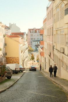 Captivating cobblestone street in Lisbon with pastel buildings and pedestrians