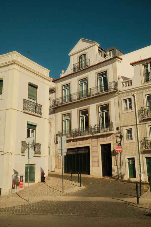 Free Historic Lisbon street with traditional Portuguese architecture under a bright afternoon sky. Stock Photo