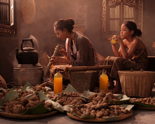 Free Mother and daughter preparing traditional Jamu in an Indonesian home setting. Stock Photo