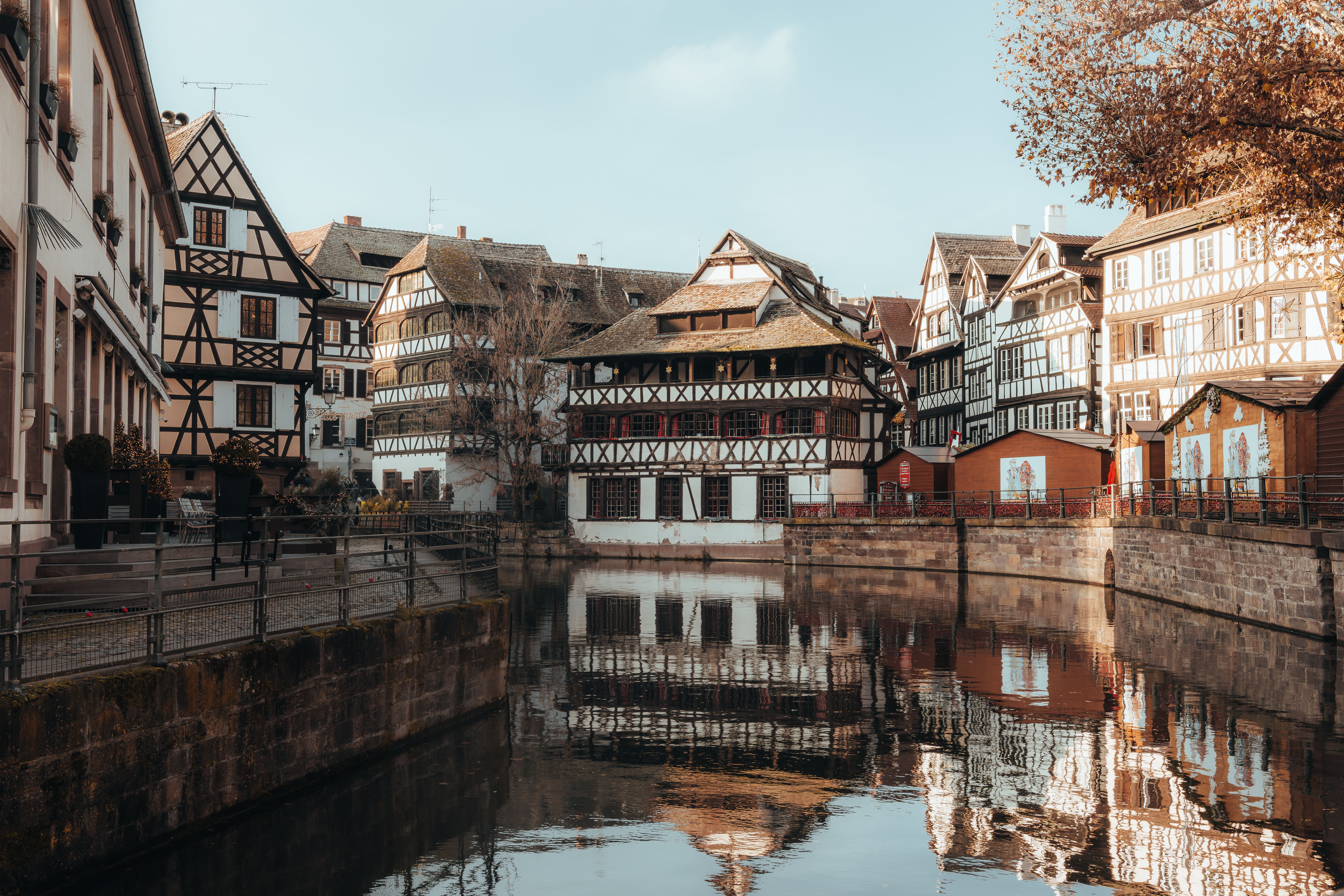 Scenic view of traditional half-timbered houses in Strasbourg's Petite France reflecting on calm water.