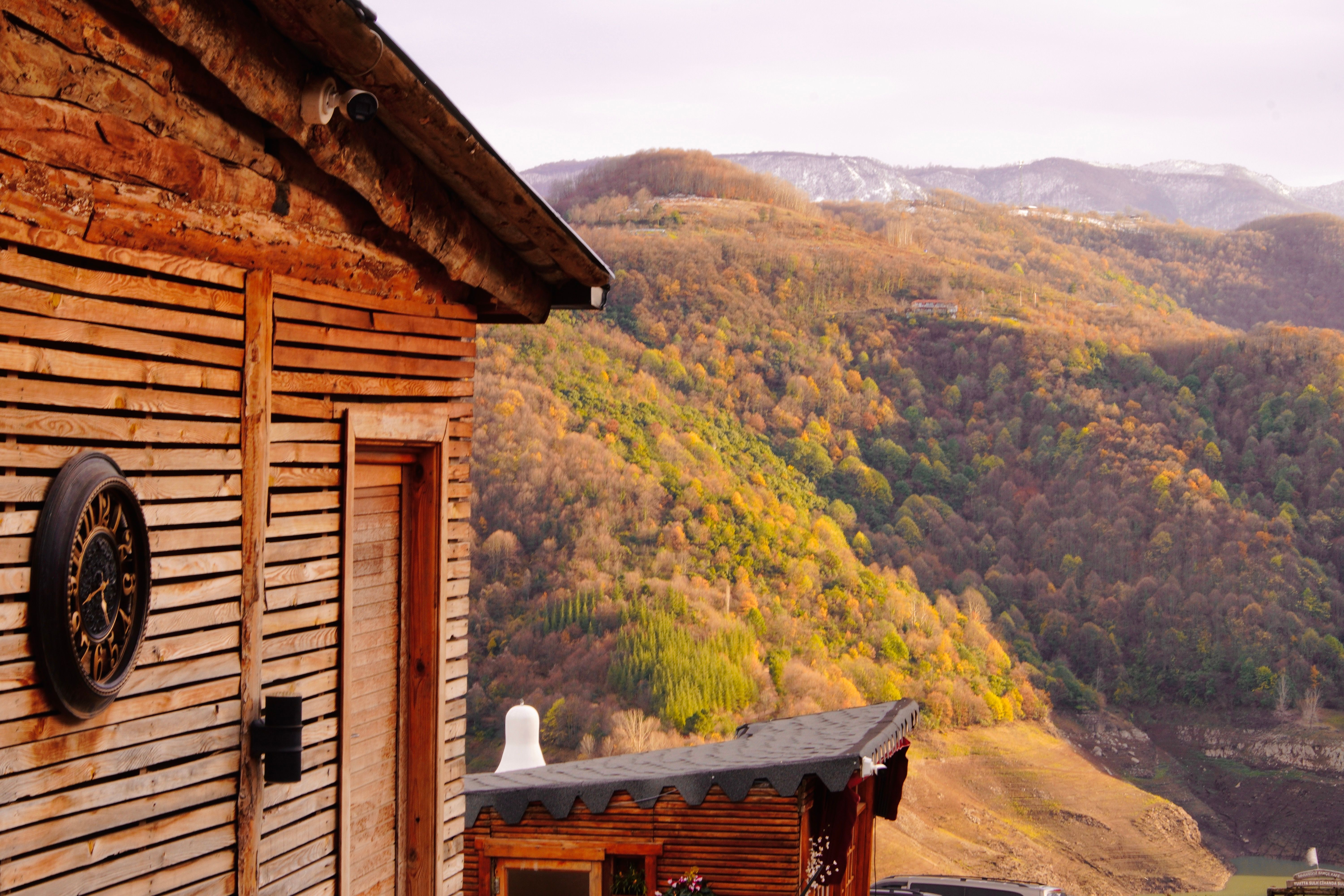 Chalet en bois confortable se détachant sur un fond de feuillage automnal flamboyant dans les montagnes.