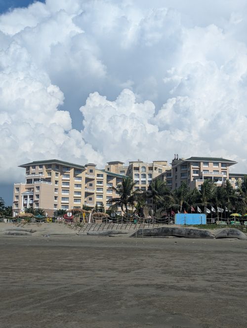 Free A picturesque seaside resort by the beach under a dramatic cloudy sky, perfect for vacation imagery. Stock Photo