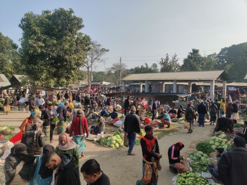 Free A vibrant outdoor market scene with people buying and selling fresh vegetables. Stock Photo