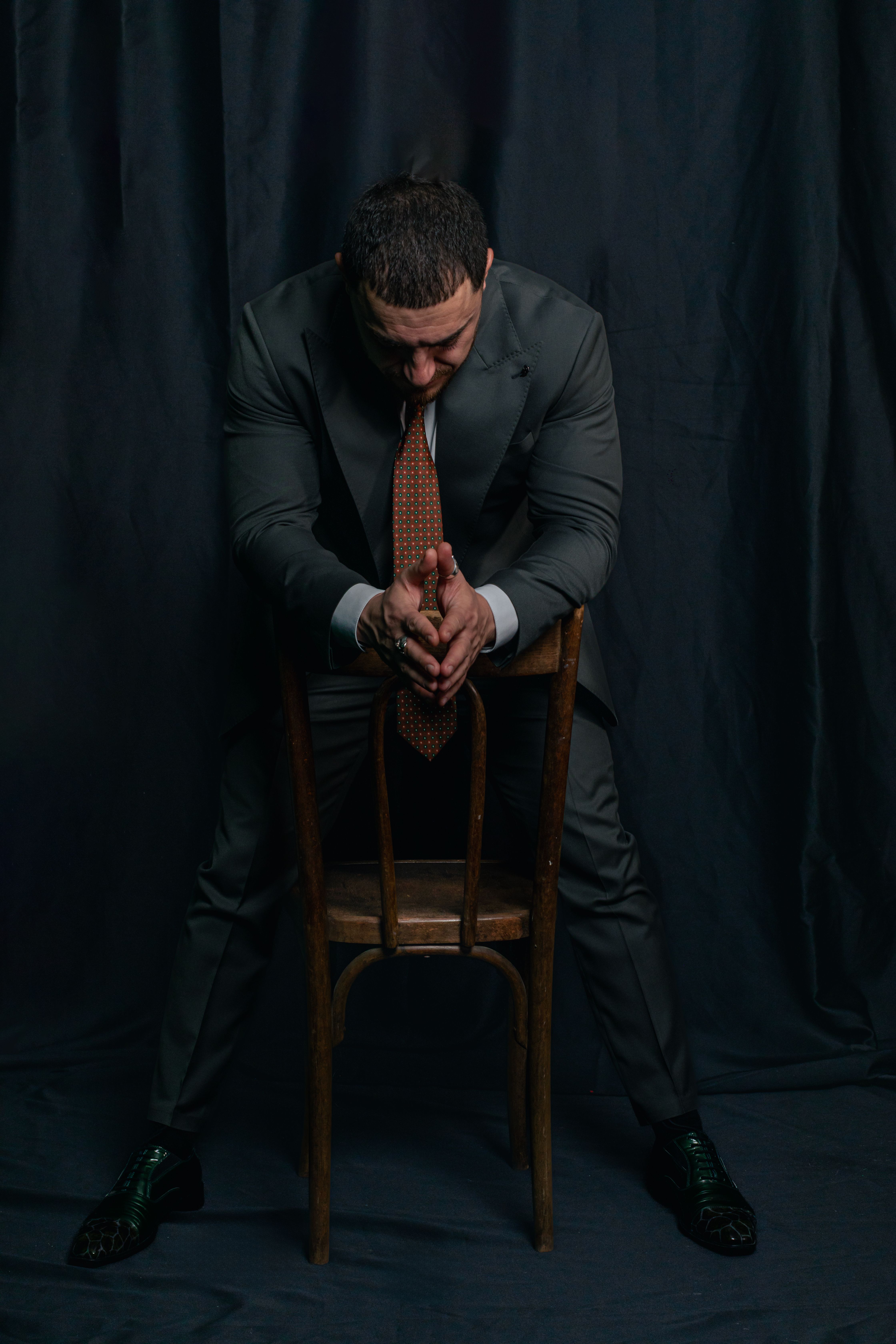 Businessman Deep In Thought on Wooden Chair