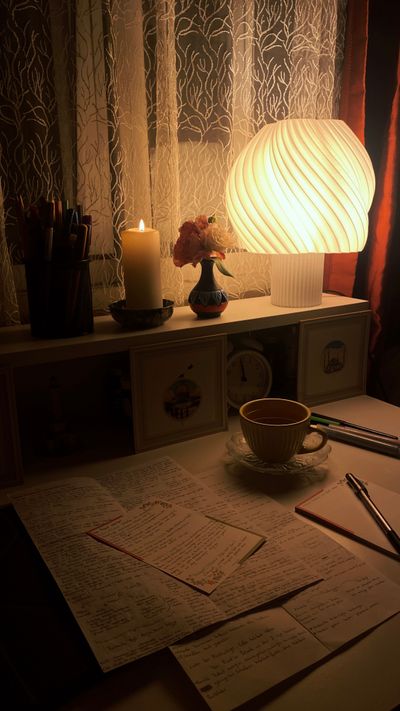 Study desk with a warm lamp, candle and handwritten notes, photo by Hedefneydii on Pexels