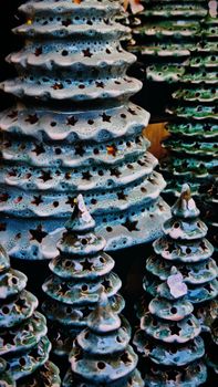 Artistic display of ceramic Christmas trees with star-shaped cutouts, festive decoration.