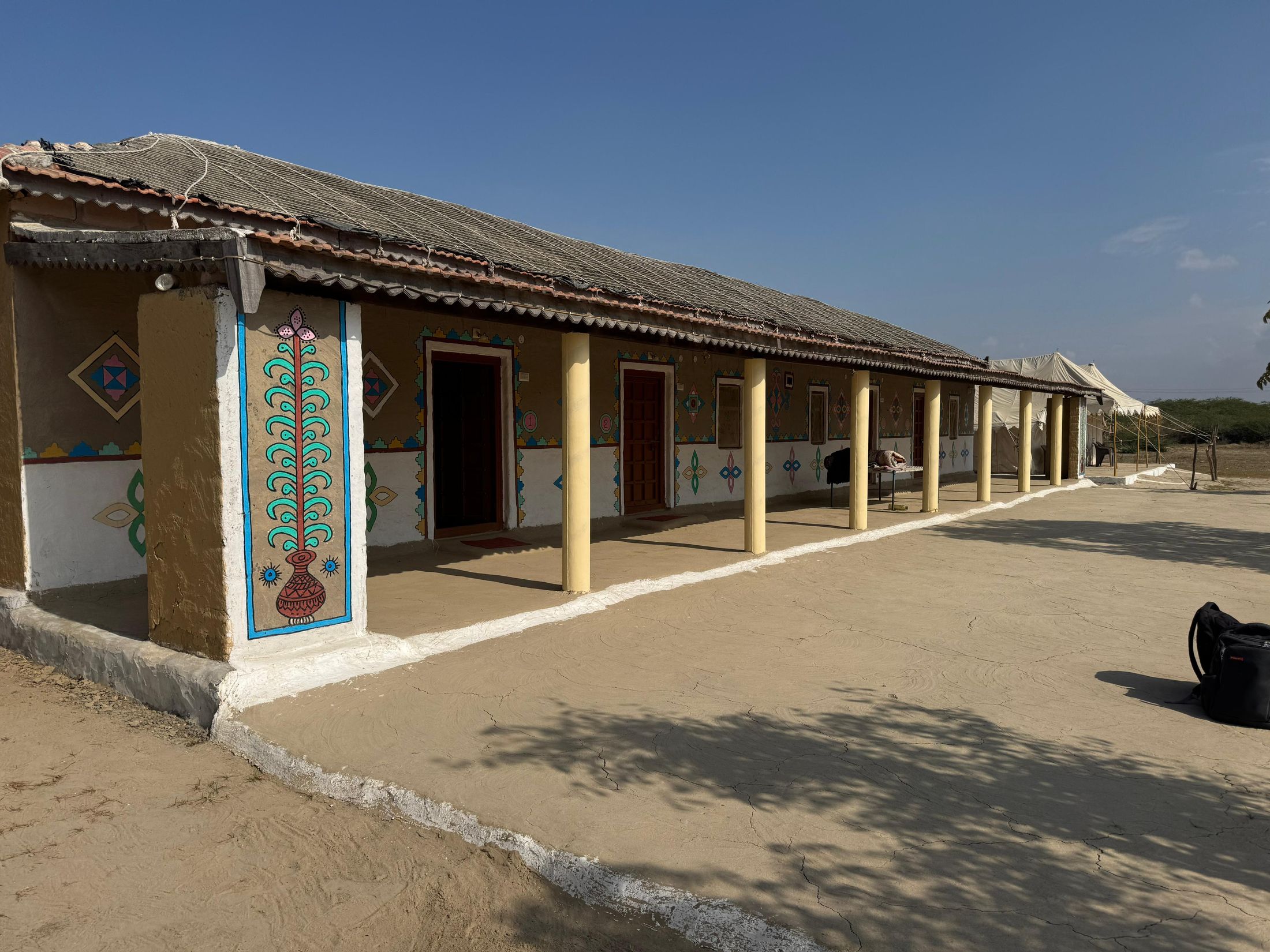 Traditional painted mud house with a columned veranda