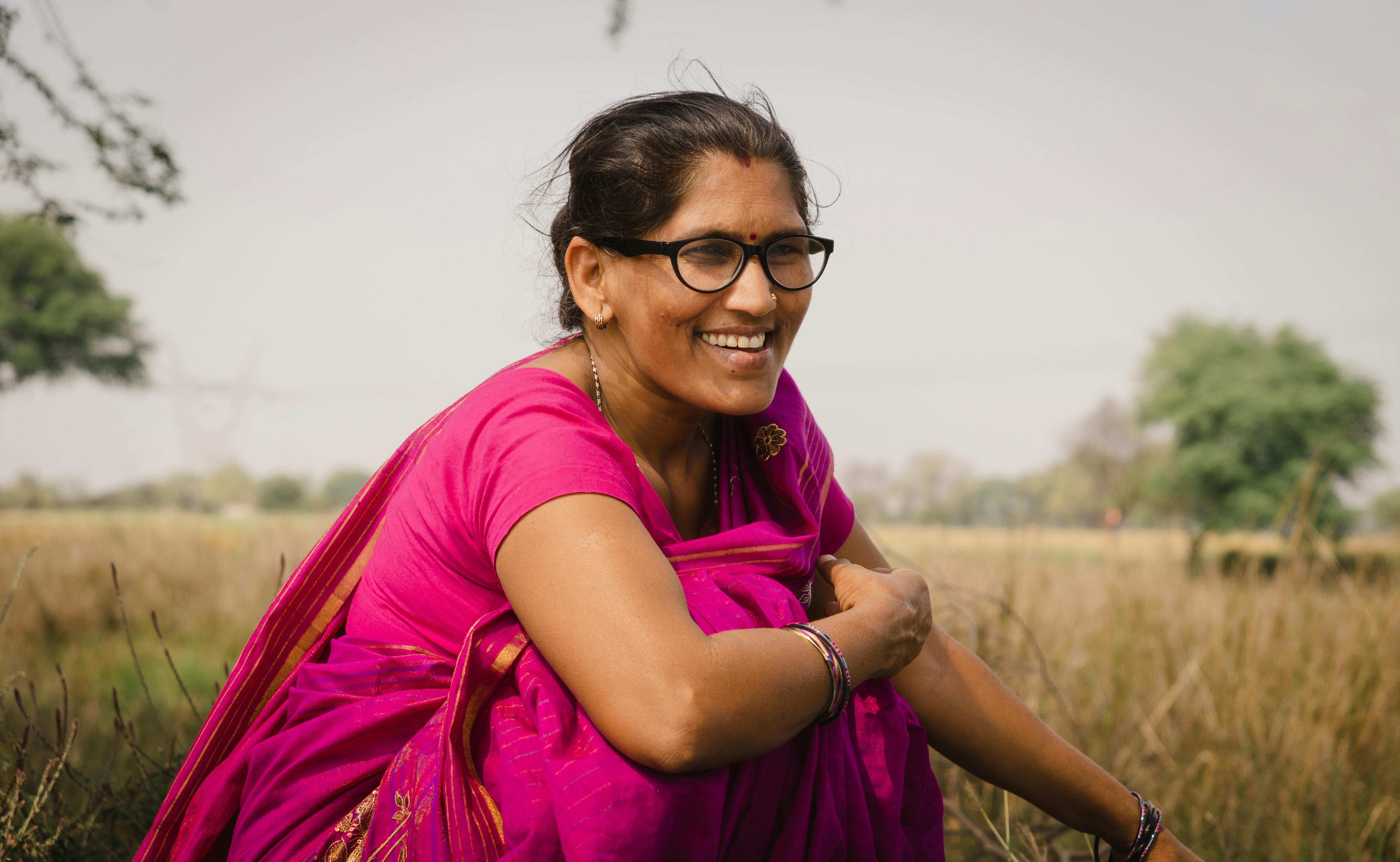 De franc Dona índia somrient amb un sari rosa gaudint del camp a l'aire lliure. Foto d'estoc