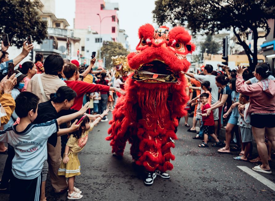 Lion dance performance captivating a lively crowd during the Lunar New Year in Ho Chi Minh City, Vietnam.