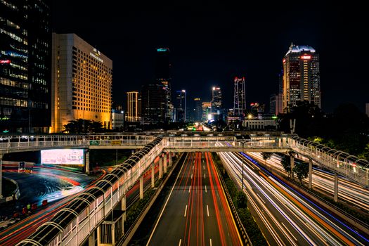 Long exposure night shot capturing Jakarta's vibrant skyline and bustling traffic.