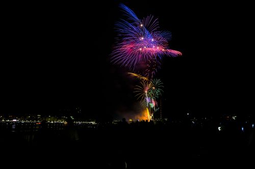 Free Colorful fireworks light up the night sky over the city, creating a dazzling spectacle. Stock Photo