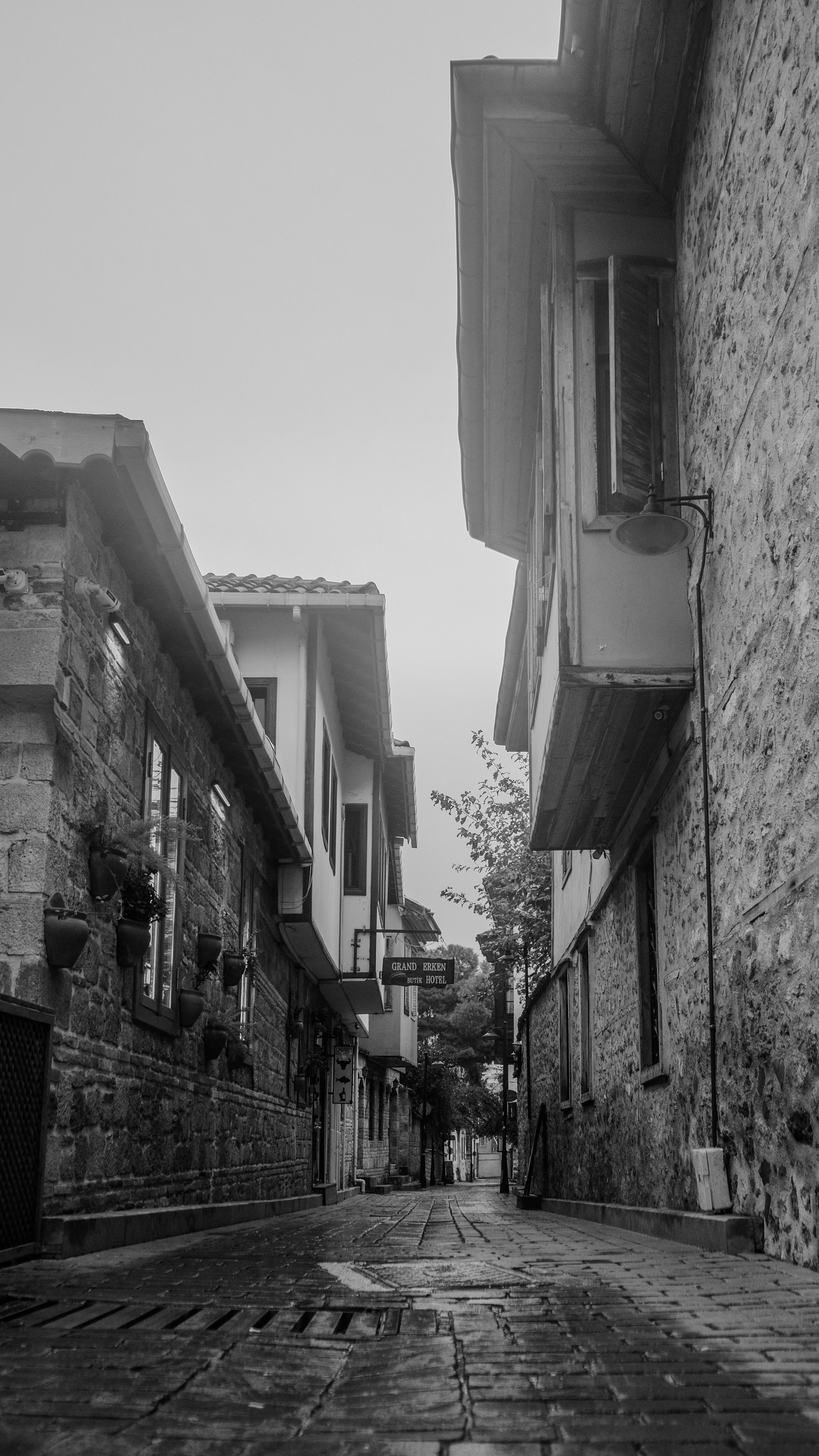 Kostenlos Eine nostalgische Kopfsteinpflastergasse mit historischer Architektur in Schwarz-Weiß. Stock-Foto