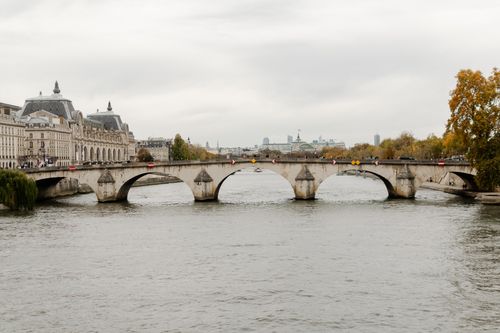 Free Historic Pont Neuf bridge in Paris spans the Seine River on a cloudy autumn day. Stock Photo