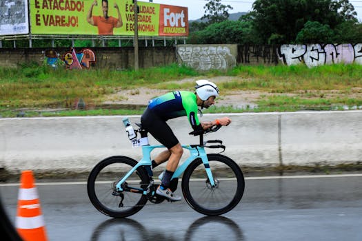 Professional cyclist competes in a race on a rainy day, wearing a helmet and racing gear.