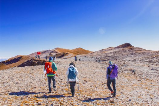 Hikers explore the rocky terrain of Mount Uludağ under a clear blue sky.