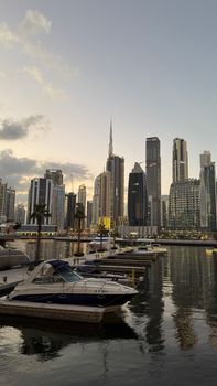 Stunning view of Dubai Marina's iconic skyline with boats at sunset.