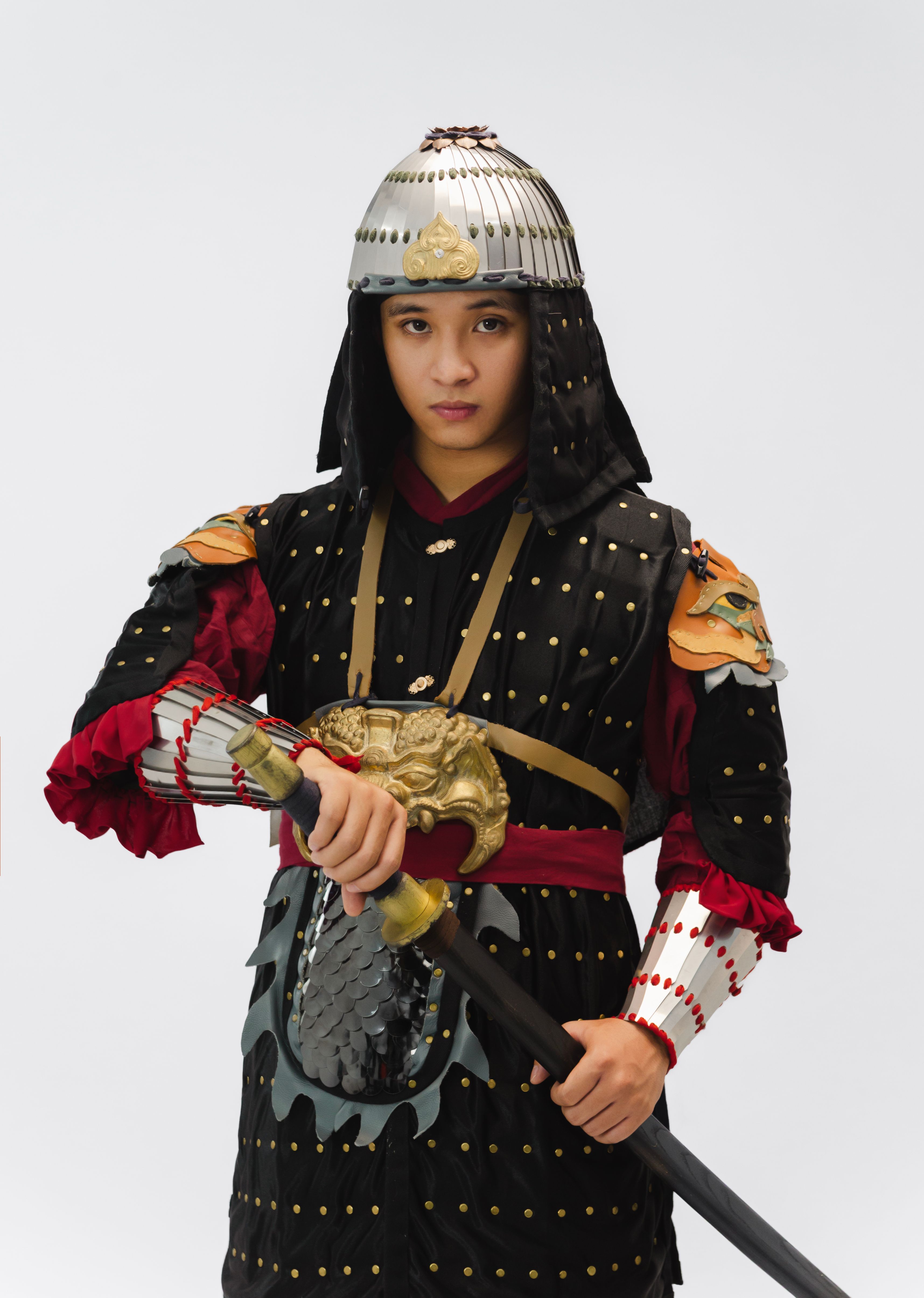 A person dressed in authentic samurai armor holding a katana, showcasing historical Japanese warrior attire.