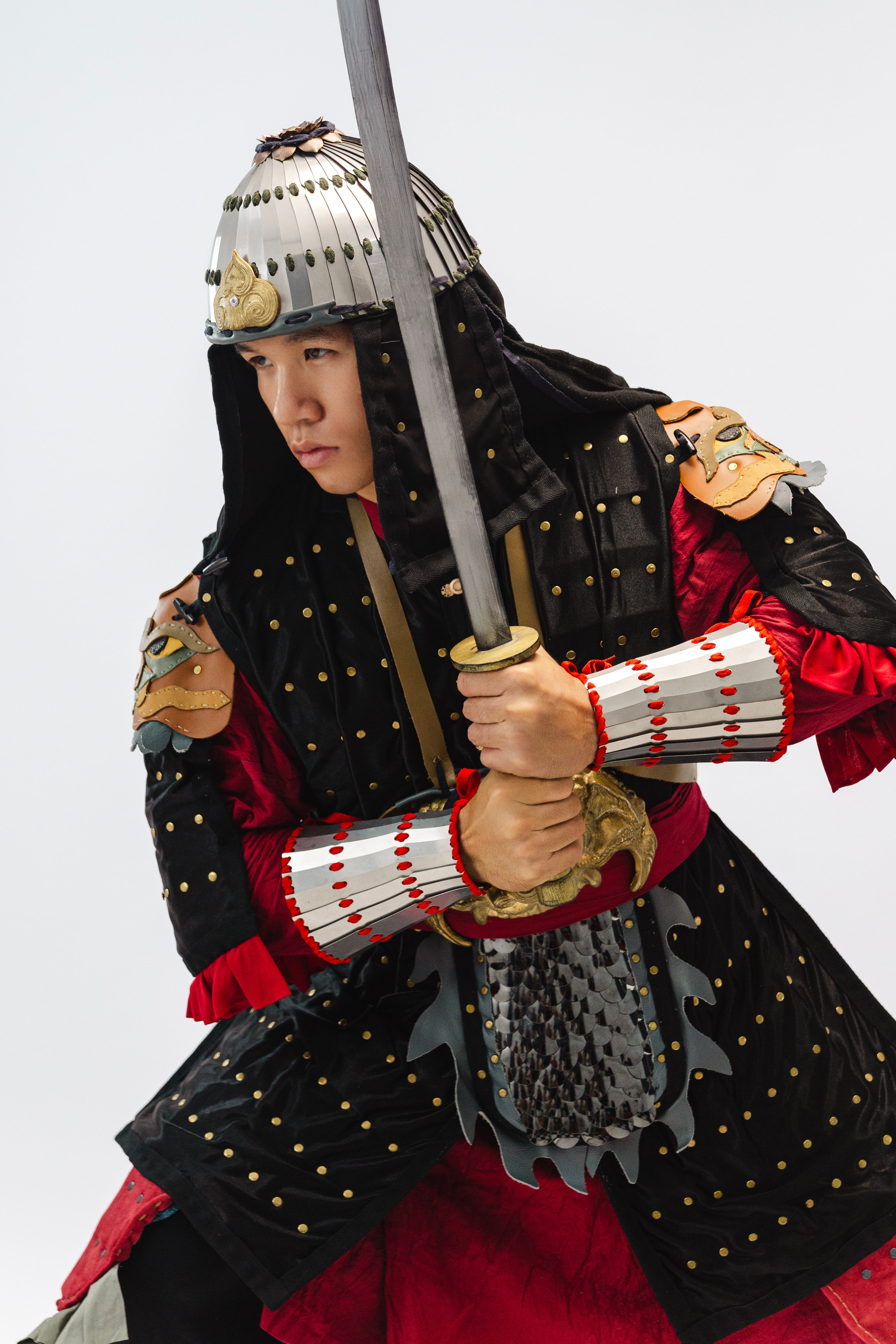 A warrior dressed in traditional armor ready for battle, wielding a sword.