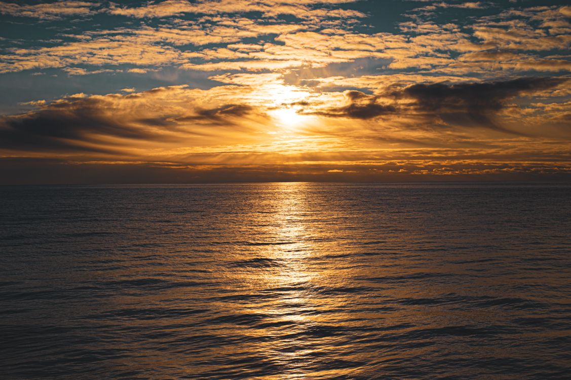 Golden Sunset Over Calm Ocean Waves · Free Stock Photo