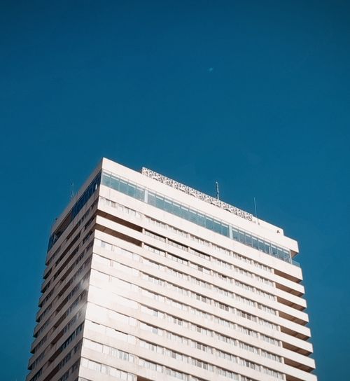 Free Captivating shot of a modern high-rise against a vivid blue sky, perfect for architectural themes. Stock Photo