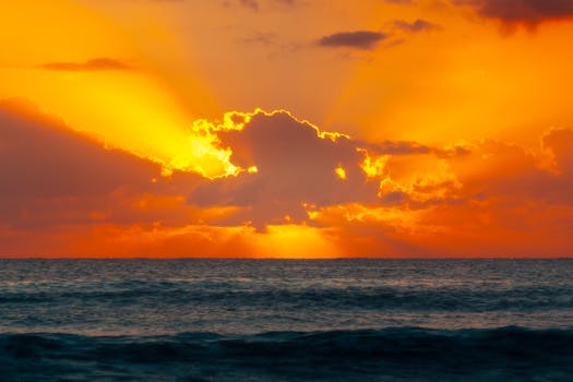 Breathtaking sunrise over the ocean at Akumal Beach, Mexico with vibrant orange hues.