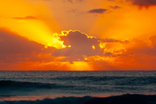 Stunning orange sunrise over the waves at Akumal Beach, Quintana Roo, Mexico.