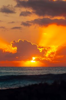 Stunning sunrise at Akumal Beach, Quintana Roo, with vibrant orange and yellow hues.