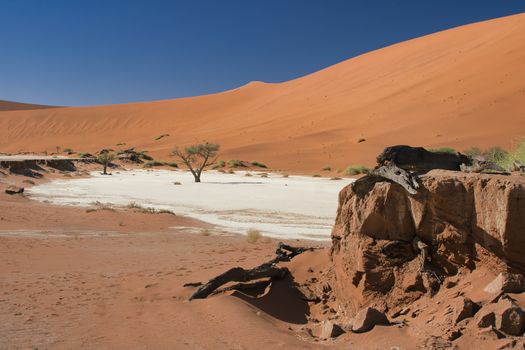 Breathtaking view of Sossusvlei's red dunes and white salt pan in the Namib Desert.