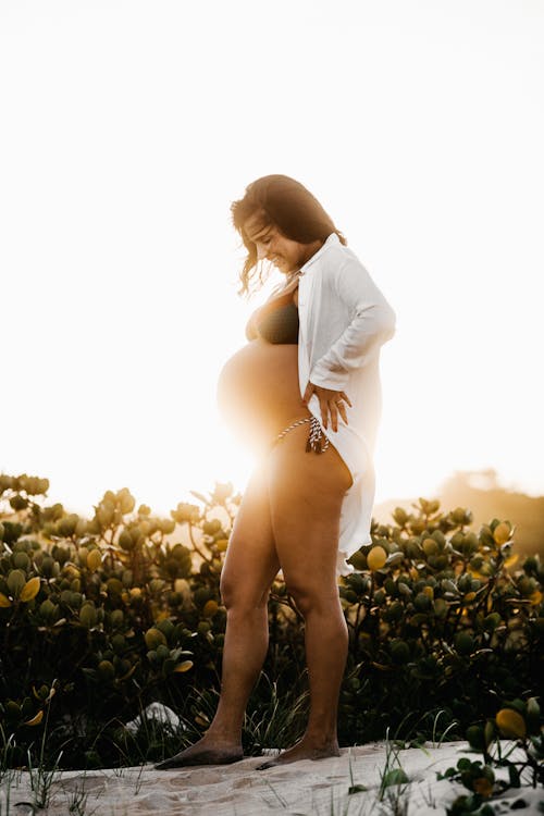 Pregnant Woman Standing Beside Plants
