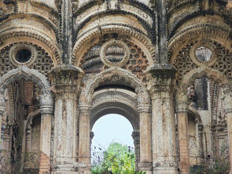Intricate stone carvings and arches in historical ruins, showcasing architectural artistry.