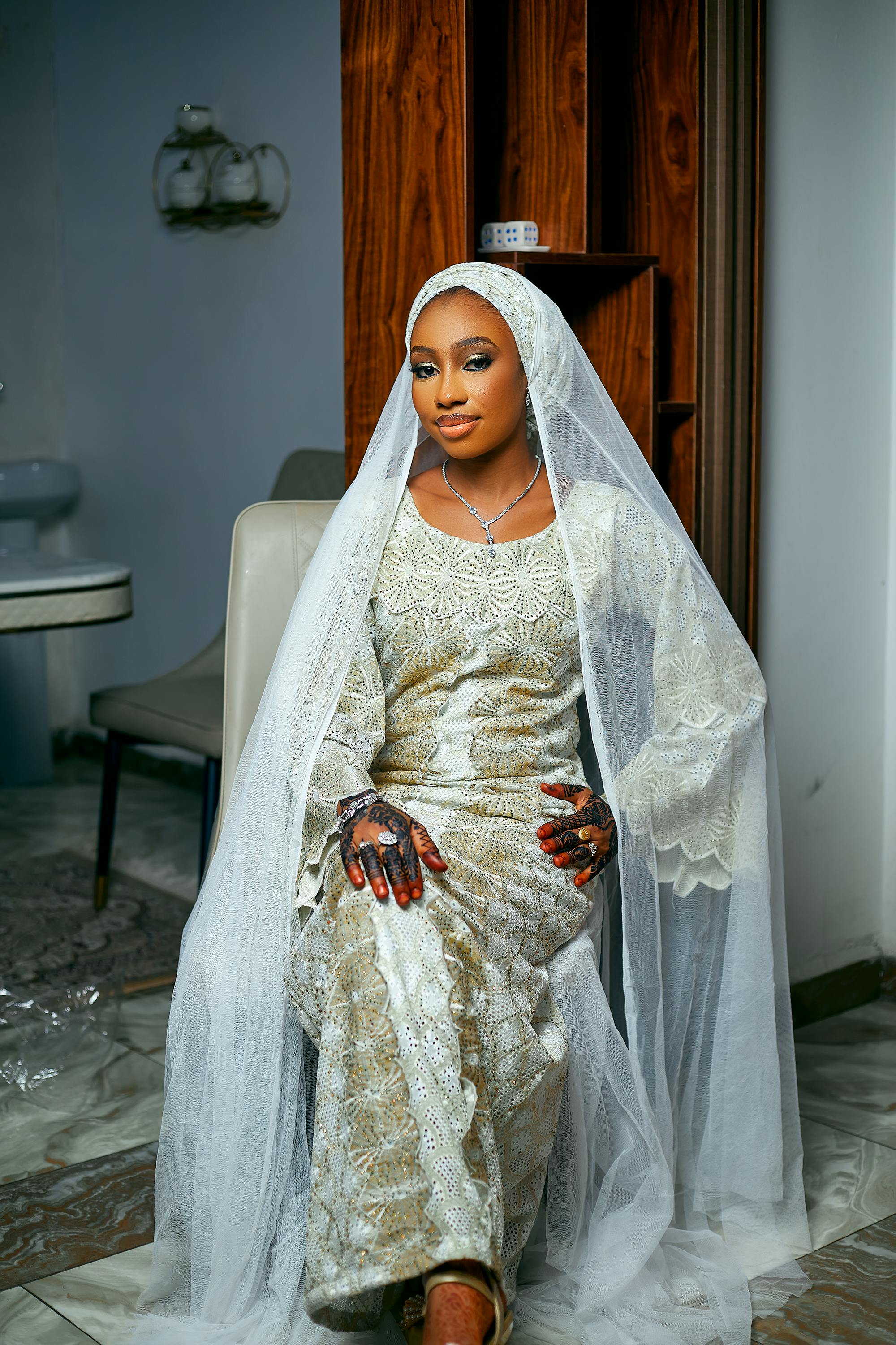 De franc Una dona amb un vestit de núvia tradicional de luxe posa a l'interior, mostrant elegància cultural. Foto d'estoc