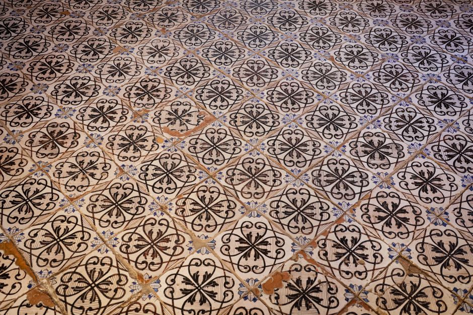 Ornate vintage tiles with intricate black floral designs indoors.